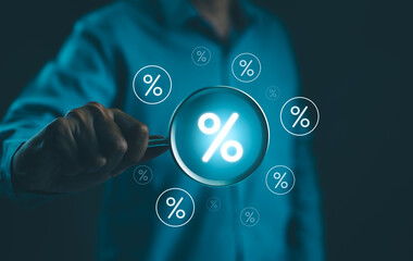 Interest Rate and Dividend Concept. Businessman holds a magnifying glass with virtual percentage...