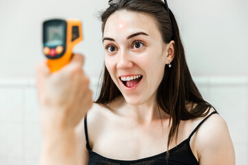Woman Having Temperature Checked with Infrared Thermometer