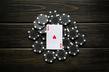 Lucky sign or winning poker game layout on a vintage club table with the ace of hearts and black chips