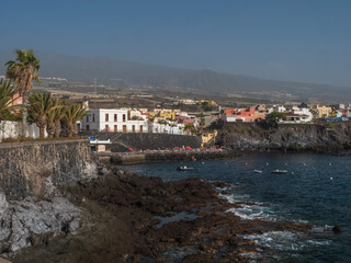 Fototapeta premium Views of the picturesque Alcala village with traditional architecture houses, small tranquil cove with beach and pier crowded with sunbathing people. Tenerife, Canary Islands, Spain.