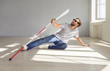 Disabled deaf visually impaired man falls down while walking with stick indoors. Vulnerable...