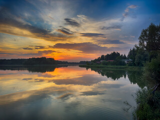 Serene Fishing Lake: A peaceful scene by the tranquil waters of a secluded fishing lake. Surrounded by lush greenery and framed by a clear blue sky, this picture captures the essence of a perfect day 