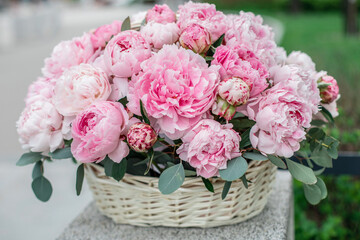 
Beautiful bouquet of pink peonies flowers in wooden basket
