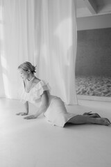 Black and white photo of an elegant woman with blonde bob haircut and red lipstick posing on the...