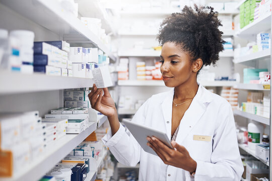 Black woman, tablet and pharmacist check inventory for medicine, stock or reading product label. Tech, pharmacy and medical worker with drugs for online prescription order, information or healthcare - Powered by Adobe