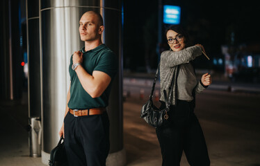 Business professionals walking confidently outdoors at night, holding briefcase and handbag,...