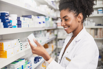 Pharmacist, black woman and reading product in clinic for medicine stock, ingredients and check information on label. Smile, female person and pills box for medical inventory, inspection and retail