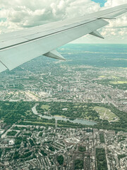 Aerial view of London. View of the city centre of London from the window of the plane. Flying over the city with blue and grey landscapes. View of the river and skyscrapers.