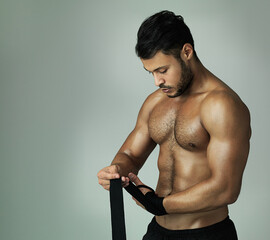 Man, topless and boxer with wrapping hands as athlete in studio background for challenge in combat...