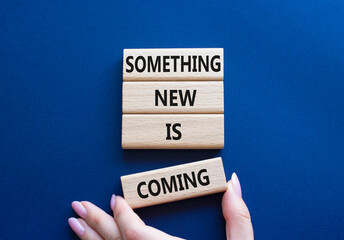 Smth New is coming symbol. Wooden blocks with words Something New is coming. Beautiful deep blue background. Businessman hand. Business and Something New is coming concept. Copy space.