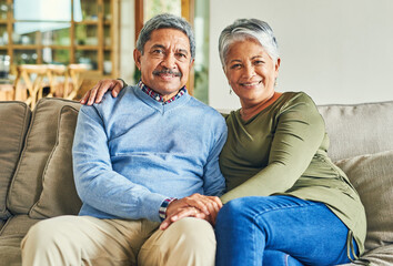 Happy, portrait and elderly couple on sofa for hug, wellness and pleased for successful retirement....