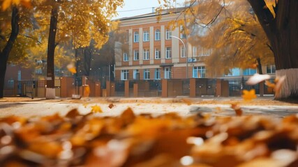 Autumn courtyard of an old school, covered with yellow leaves, on a warm sunny day. Beginning of the school year. Students and teachers rejoice in meeting after summer vacation. The educational .