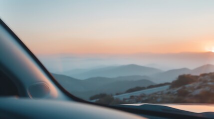 Fototapeta premium A beautiful sunrise view from a car on a mountain road, with misty hills and a serene atmosphere in the background.