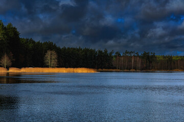 Dramatyczne chmury nad wiosennym jeziorem © Robert