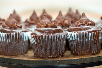 Delicious chocolate cupcakes lined up on wood plate