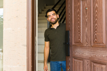 Man greets guests with a warm smile at his front door, creating a welcoming atmosphere