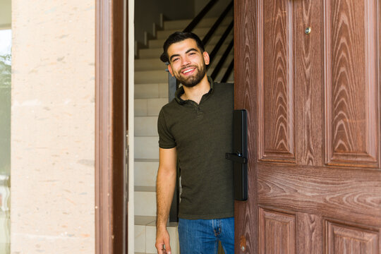 Man greets guests with a warm smile at his front door, creating a welcoming atmosphere - Powered by Adobe