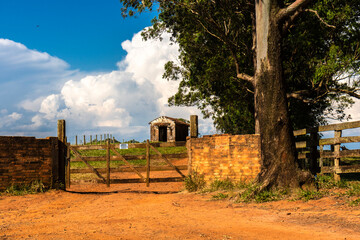 Wooden gate with a sign with the words Warning - Keep the gate closed in portuguese and an...