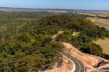 View of an empty paved rural road, flanked by Atlantic forest and eucalyptus fields in a mountain range in Brazil