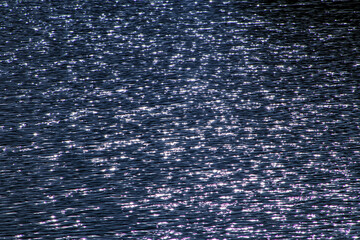 Reflection of the sun in the water. Texture water ripples in detail on the lake in Brazil