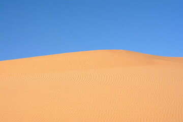 Sunset over the desert of Al Khatim in Abu Dhabi, Emirates. Golden Sand Dune Desert Landscape Panorama. Beautiful sunset over the sand dunes