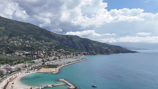 A stunning aerial view of colorful houses in Menton, France, captured by a drone on a sunny day. This video showcases the picturesque C&ocirc;te d'Azur town with charming architecture and blue sea.