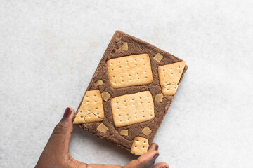 Overhead view of chocolate fudge with cookies and fudge on a white tray, Top view of hazelnut chocolate fudge slab on a white granite countertop