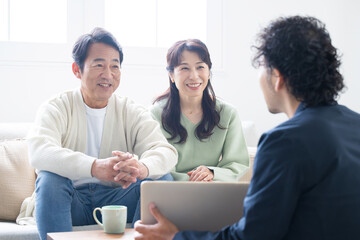 営業マンの説明を受ける笑顔の50代夫婦　投資や保険、不動産など
