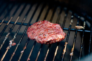 grilling juicy beef patty on grill