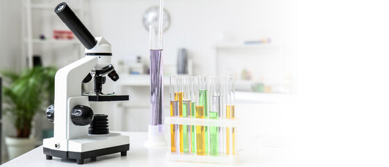 Modern microscope and test tubes on table in medical laboratory