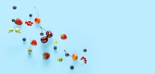 Different flying berries on light blue background with space for text