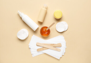 Composition with sugaring paste, cotton pads and cosmetic products on beige background, top view. Epilation concept