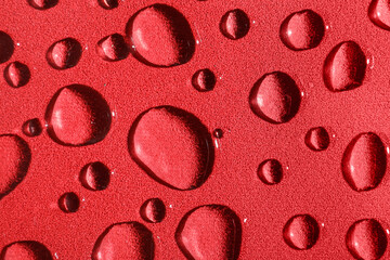 Many water drops on red background