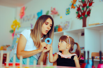 Speech Therapist Teaching a Child the Correct Pronunciation. Kid learning about speaking correctly in a logopedics office 
