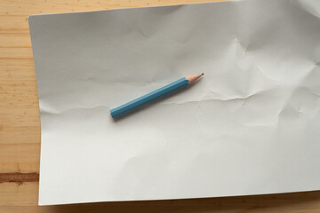 short grungy pencil on blank card with crease lines and wood