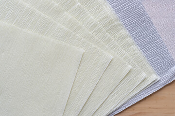 pile of crepe paper sheets arranged with staggered corner edges on wood