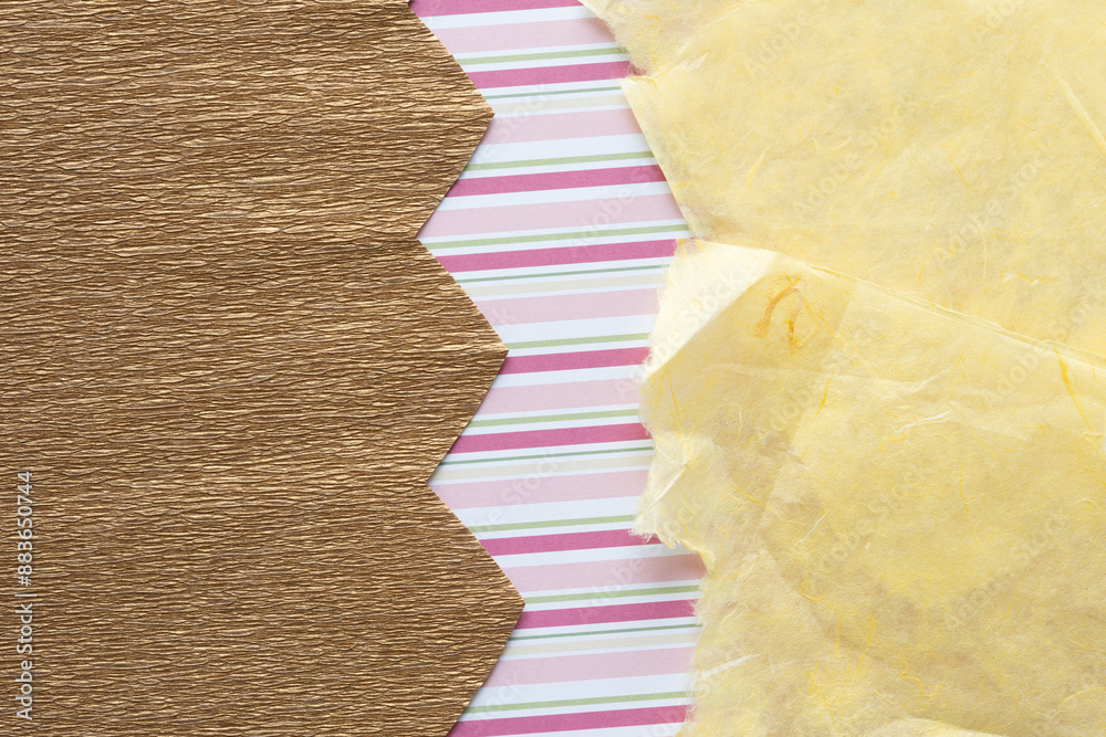 Wall mural gold crepe paper with zig-zag edge and yellow tissue paper with torn edges on paper with pink stripe