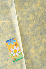 decorative floral tag on textured yellow tissue paper background
