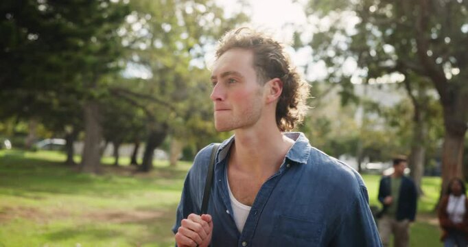 Happy man, student and walking with backpack at park for education, learning or outdoor journey. Young male person or learner in stroll with bag to college, university or campus in forest or nature