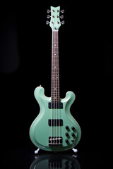 Fototapeta premium Elegant Sea-Green Bass Guitar in Focus: A Striking Statement of Musicality and Performance