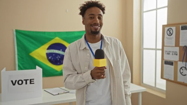 Handsome black man with a beard in an indoor electoral college room in brazil holding a microphone with a voting booth and brazilian flag in the background.
