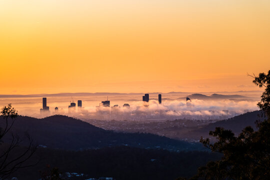 Brisbane city at sunrise covered in fog