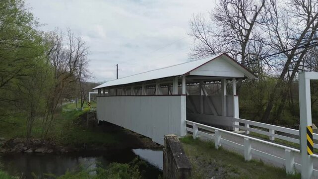 Snooks covered bridge near New Paris PA. Low level shot that pushes into the bridge and rises above its roof to show farmland beyond. Shot on an early Spring day.