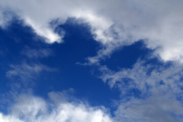 Cloudscape with blue sky and white fluffy clouds