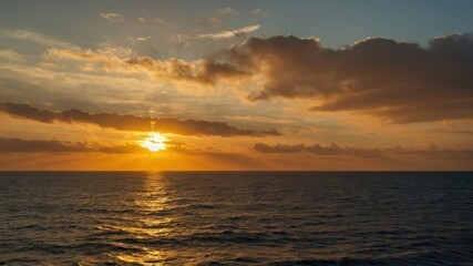 Obraz premium Golden sunset sky over the ocean with the sun dipping below the horizon, creating a serene view