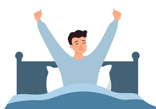 Happy young man stretch waking up in home bedroom. Smiling guy with good morning in bed.