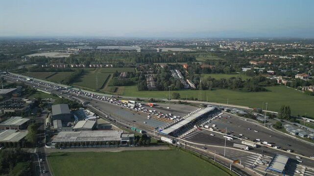 Aerial view of an Italian highway toll booth. Cars queuing up to pay the highway toll and automatic paying lanes.