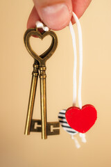Heart-Shaped Keys and Heart Charms on string being held by fingers