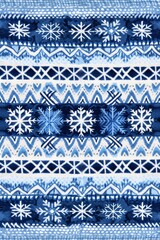A detailed Fair Isle knit pattern featuring blue and white snowflakes and geometric shapes