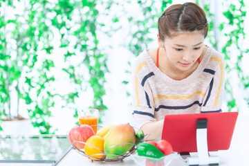 キッチンでタブレットを操作する女性